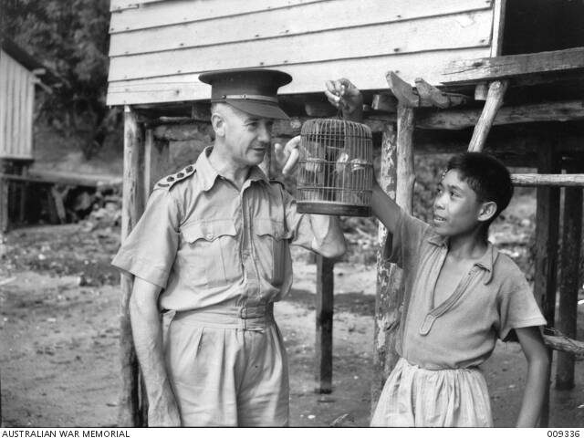 Captain Herbert Geldard with Malayan boy and caged bird